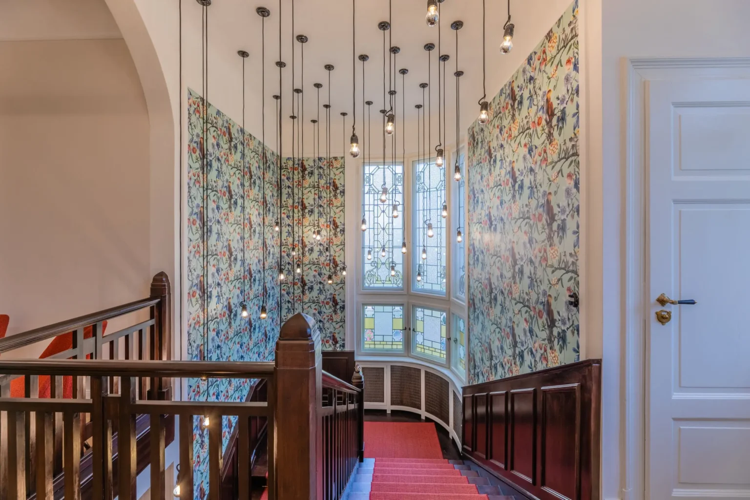 Treppenhaus mit einigen  von der Decke herabhängenden Lampen